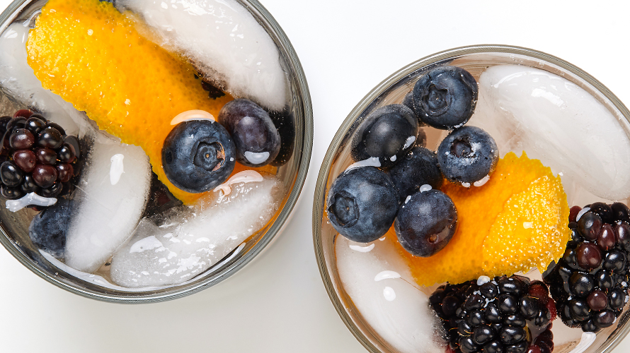 An orange rosé champagne cocktail featuring a refreshing combination of rosé champagne, triple sec, orange bitters and juicy berries.