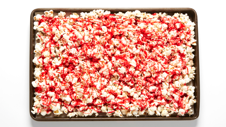 A pan of white popcorn with streaks of red on top. 