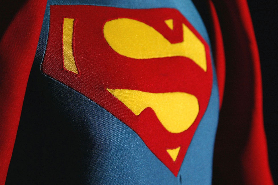 A closeup of the superman emblem on the chest of superman.