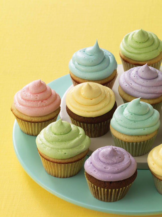 Multicoloured cupcakes sitting on a green plate.
