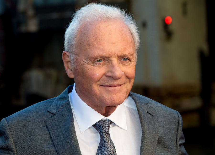 Anthony Hopkins wearing a grey suit and smiling.