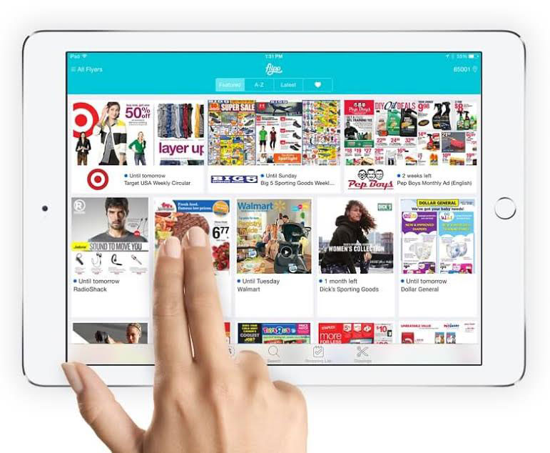 A photo of the flipp app on a tablet with two fingers touching the screen.