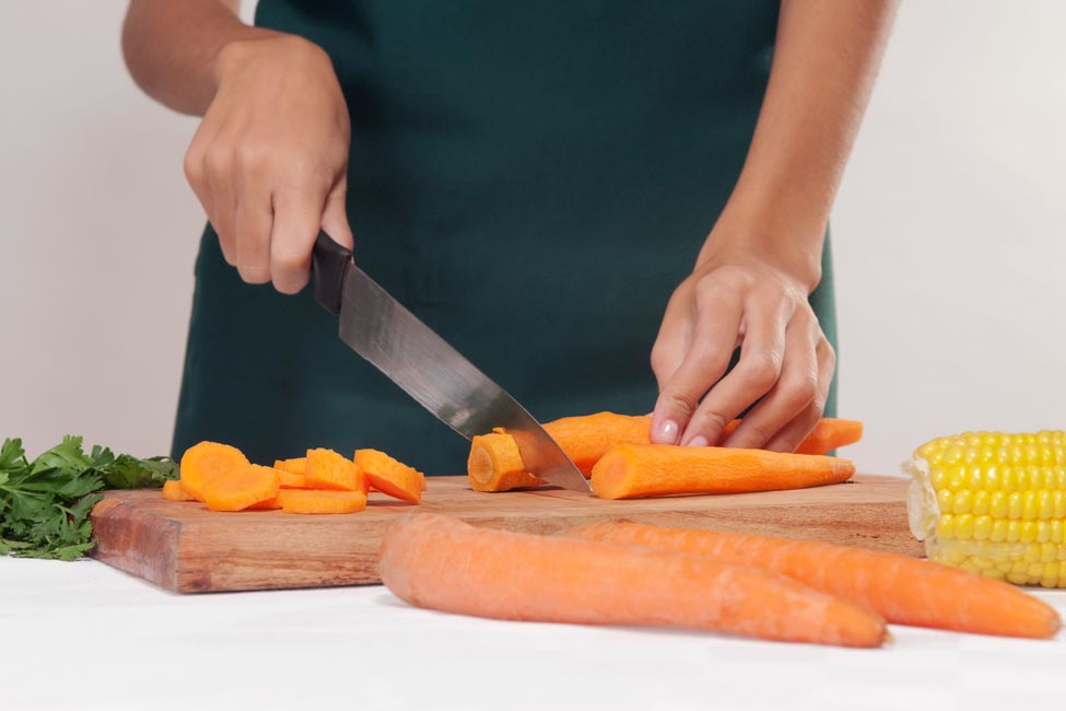 A woman slicing carrots