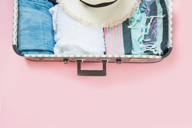 Open suitcase with rolled up clothing