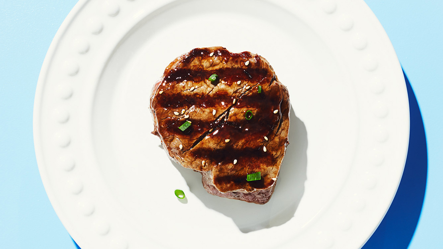 Beef tenderloin served on a white plate.