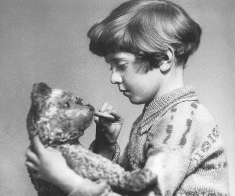 The real Christopher Robin holding his stuffed bear.