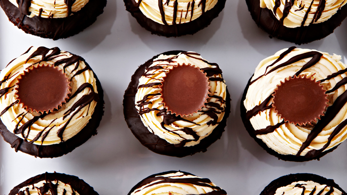 Cupcakes with mini peanut butter cups sitting on top of white icing.