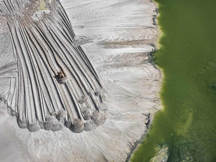 A photo of a bulldozer clearing rock near a pond in Florida.