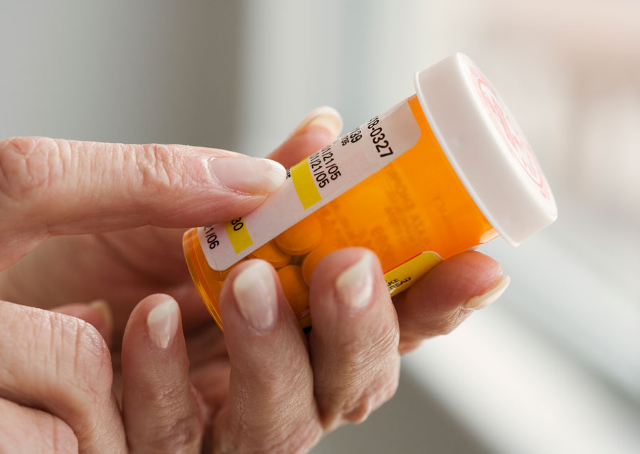 Woman holding bottle of medication.