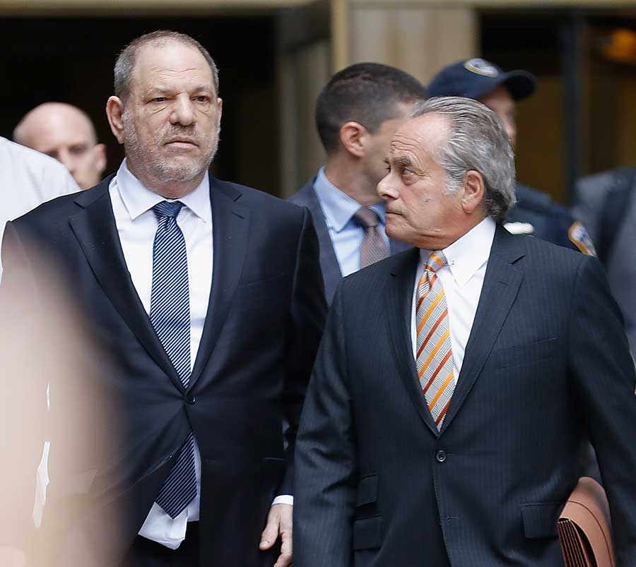 Harvey Weinstein walking alongside his lawyer.