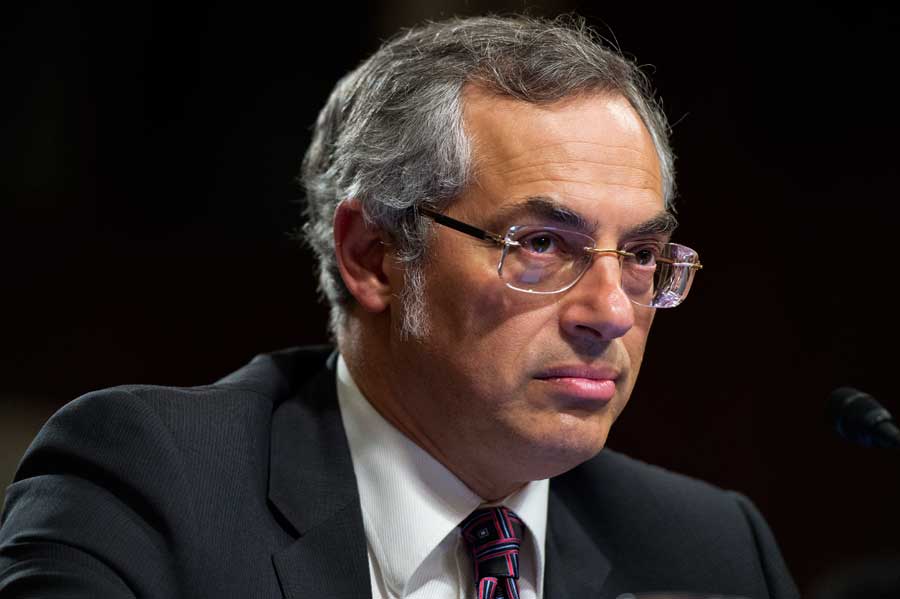 Tony Clement on a black background staring off camera.