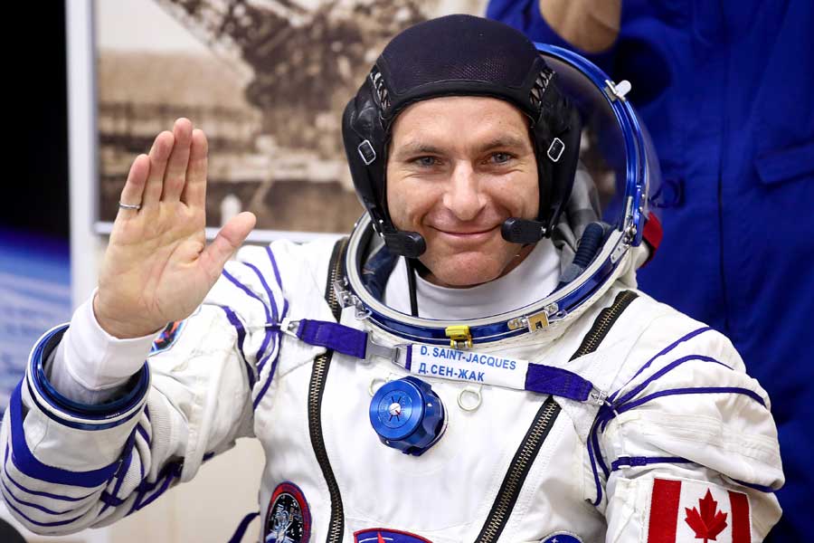 David Saint-Jacques waves in his space suit before launch to international space station.