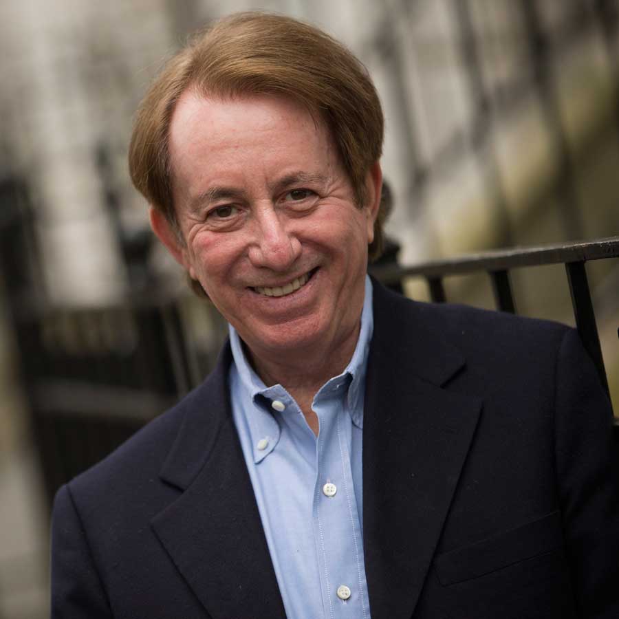 Mark Breslin smiling wearing a blue collared shirt and black suit jacket.