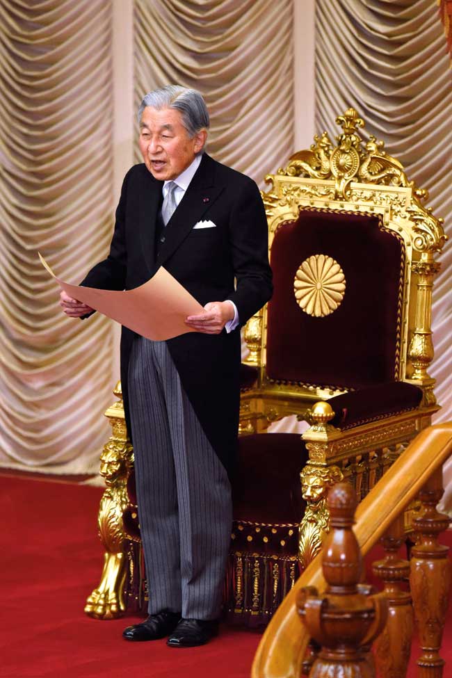 Japan’s Emperor Akihito delivers his opening address for the 195th parliament session in Tokyo as he stands in front of a gold throne.