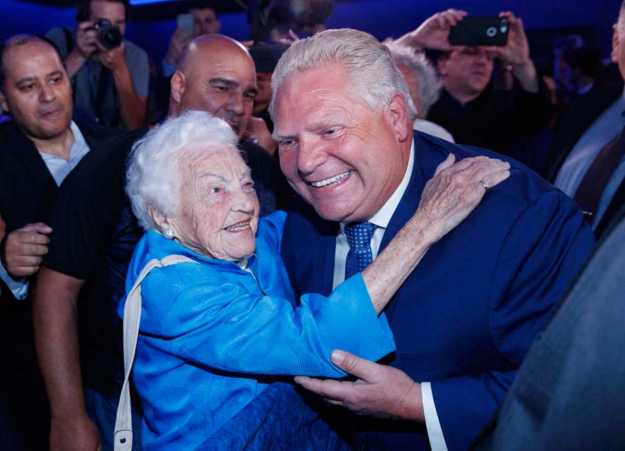 Ford and McCallion embrace at a political event both smiling.