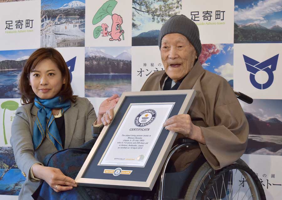 Masazo Nonaka of Japan (R), aged 112, receives a certificate for the Guinness World Records' oldest male person living title from Erika Ogawa (L), vice president of Guinness World Records Japan, in Ashoro, Hokkaido prefecture on April 10, 2018