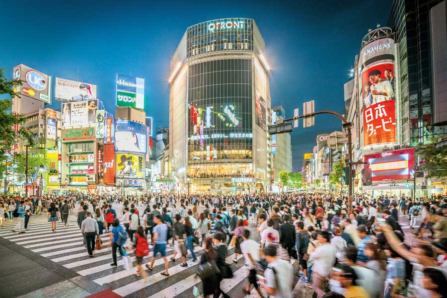 The epic pedestrian scramble at Tokyo's Shibuya crossing with Tokyo's electric billboards in the background.