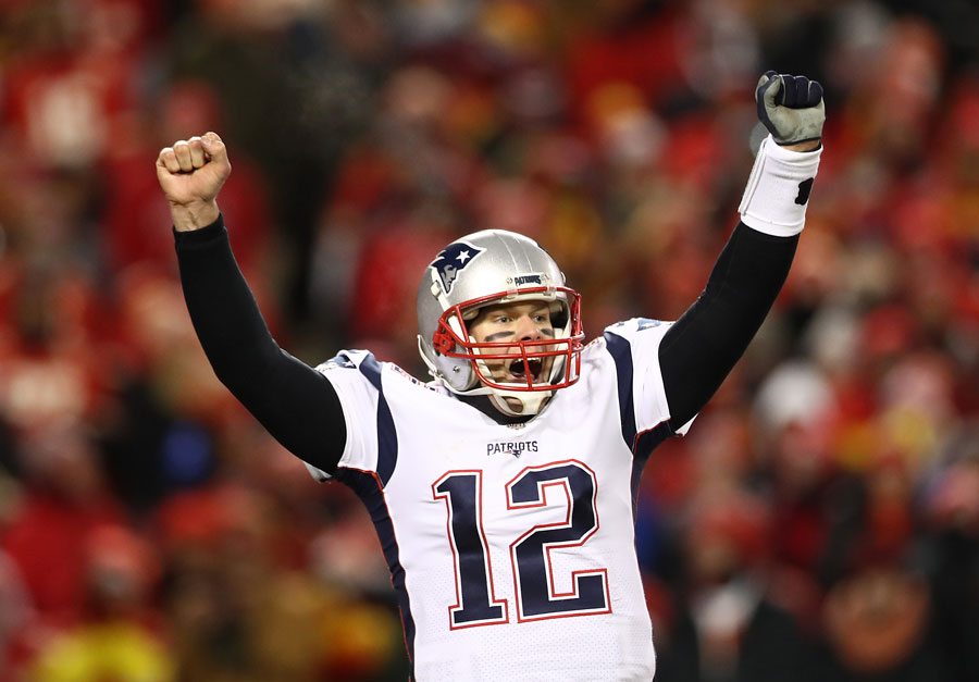 Tom Brady holds his hands up in victory.