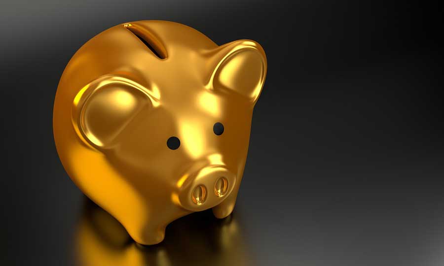 Gold piggy bank on black background.