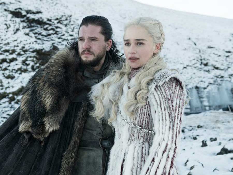 jon snow and Daenerys Targaryen stand side by side on a snow covered mountain.