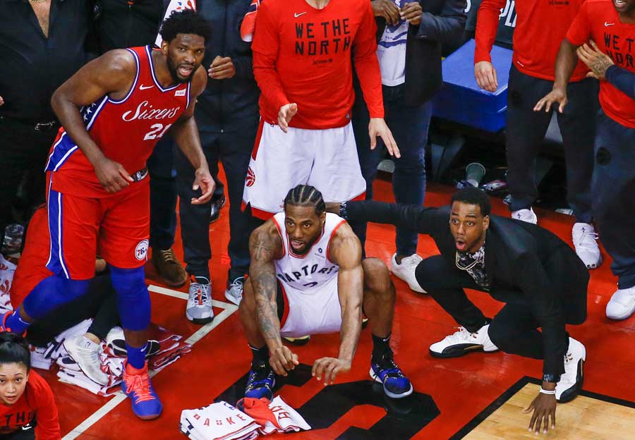 Kawhi Leonard crouches as he watches his game winning shot hang on the rim.