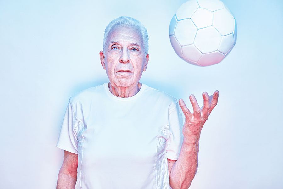 A man tossing a soccer ball in the air.