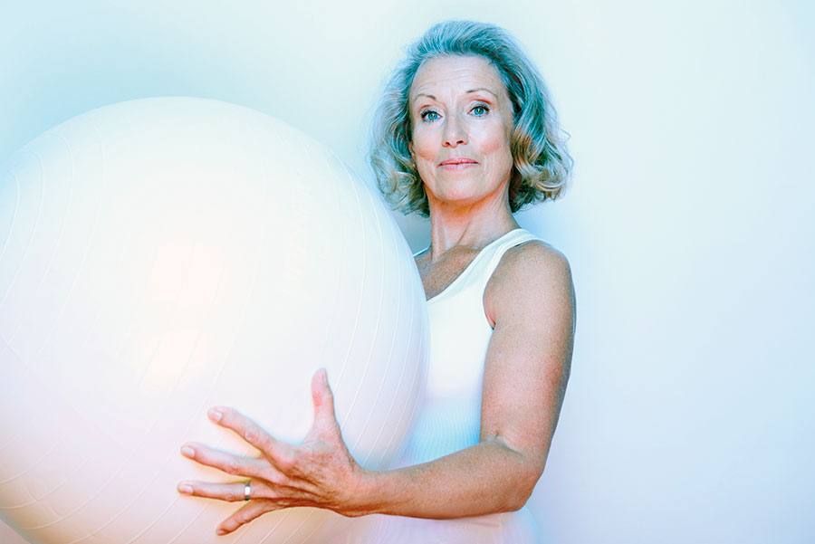 A woman holding and exercise ball