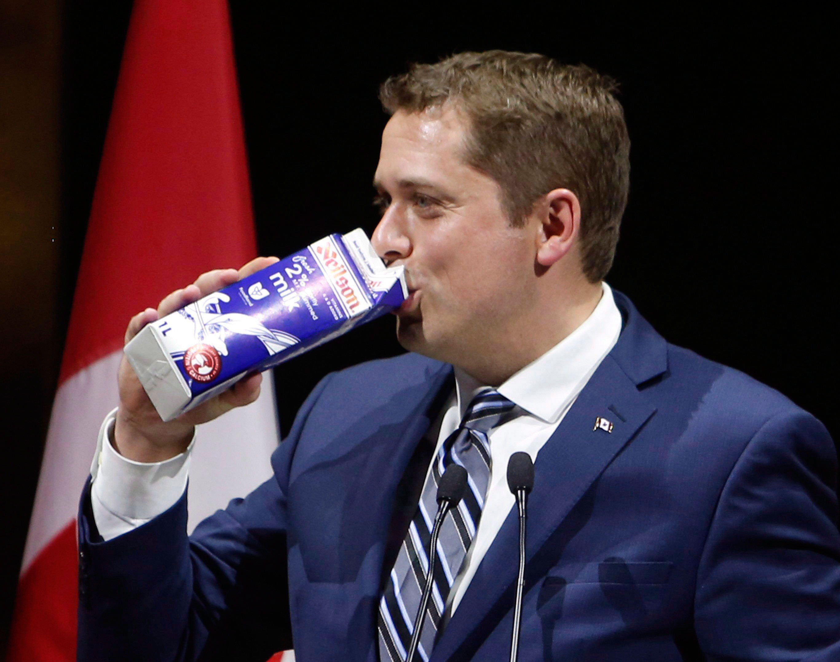 Conservative Leader Andrew Scheer drinks milk as he takes the stage at the National Press Gallery Dinner in Gatineau, Quebec, Saturday June 3, 2017.