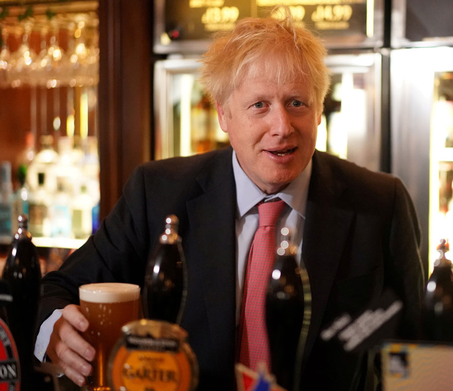 Boris Johnson holds a pint of beer behind the bar during his visit to JD Wetherspoon&#039;s Metropolitan Bar in London, on July 10, 2019.