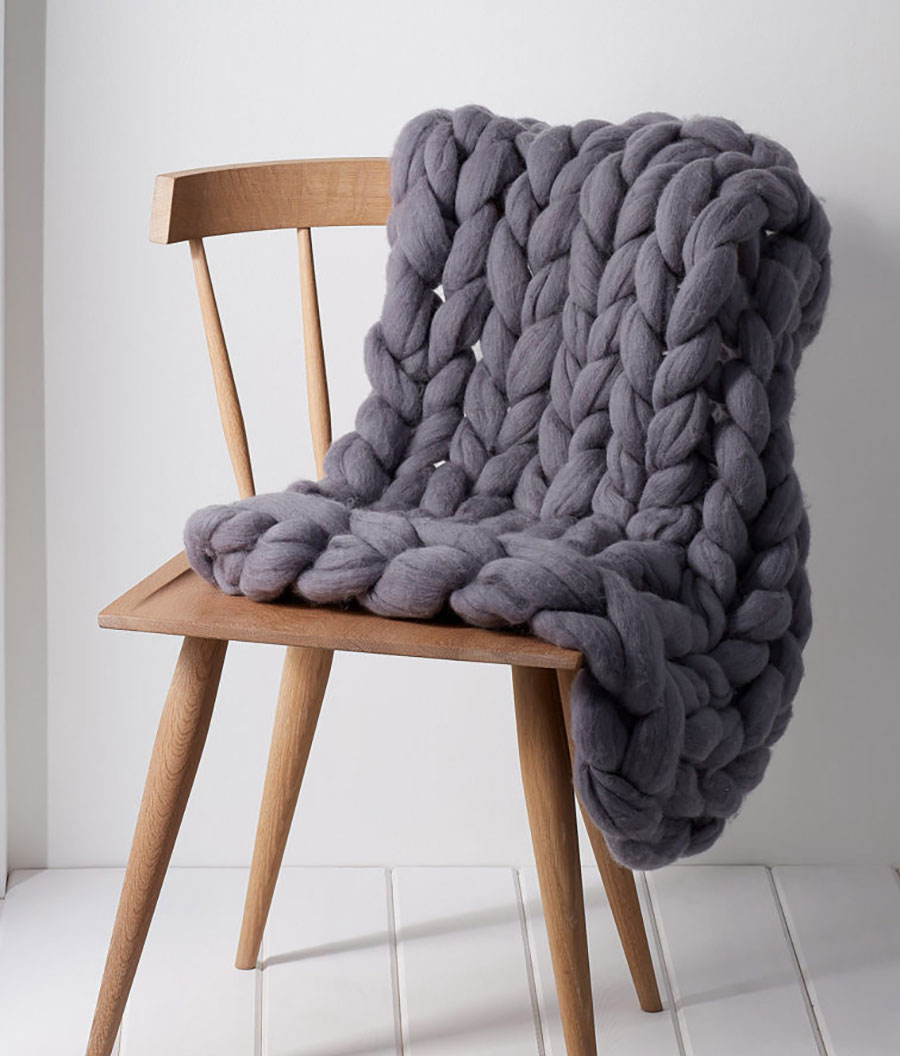 picture of a knitted blanket draped over a wooden chair