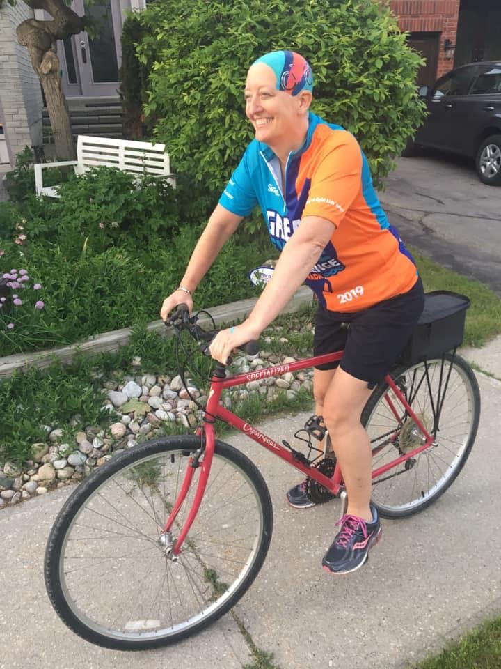 Lezli heads out for a cycling fundraiser after her two children painted her head to match her jersey.