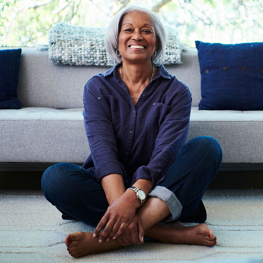 Portrait of senior woman sitting on floor at home