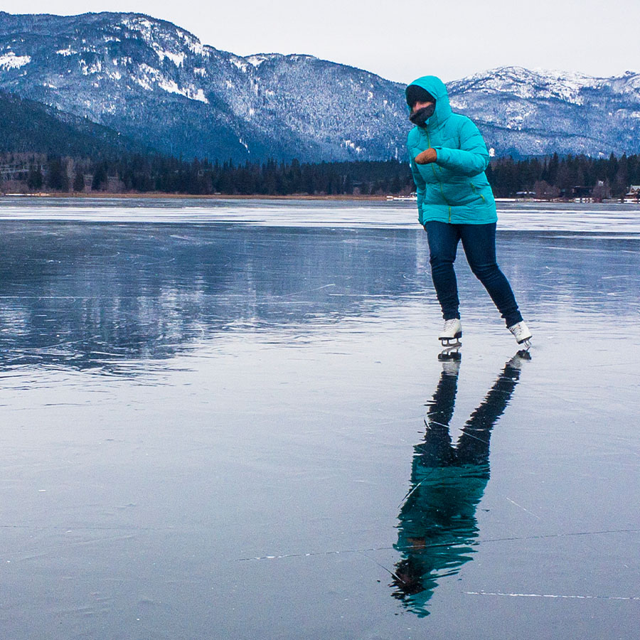 Single woman having fun ice skating on frozen Alta Lake, Whistler, British Columbia, Canada.