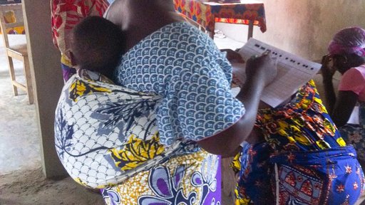 A Beninese "mama" practicing accounting with her baby.