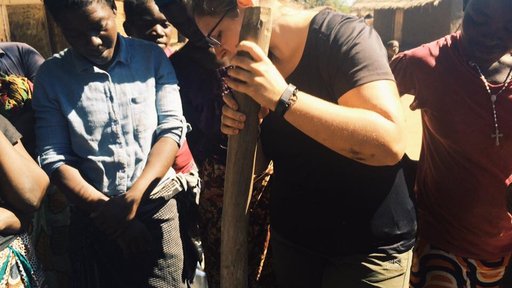 Pounding down paper soaked in water during a briquette demonstration. Once pounded to a pulp, the paper is added to an organic component such as leaves, rice husk, or wood shavings. The mixture is stirred in a bucket of water and is then pressed into briquettes using a simple wood and PVC mold.