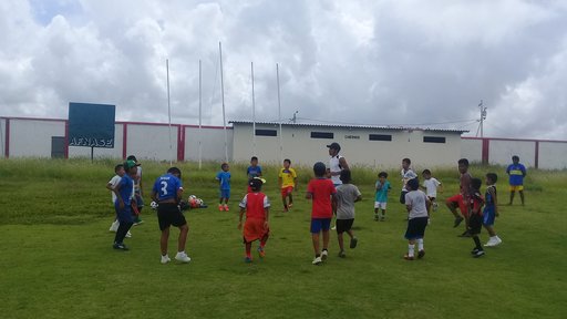 A group of youth doing soccer warm ups on a field.