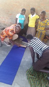 Girls observing how to make reusable menstrual pads