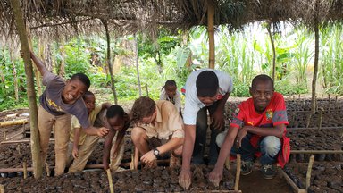 Logan and his community members plant the cocoa seeds in the nursery