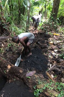Village men digging trench to lay water pipes