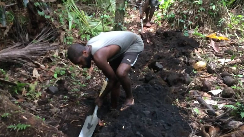 Village men digging trench to lay water pipes