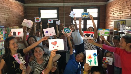 Members of the Art Club at the Escuela Basica show off their finished drawings/paintings.