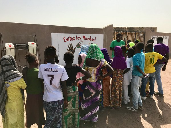 Badara Drame instructs the children on the importance of handwashing.jpg