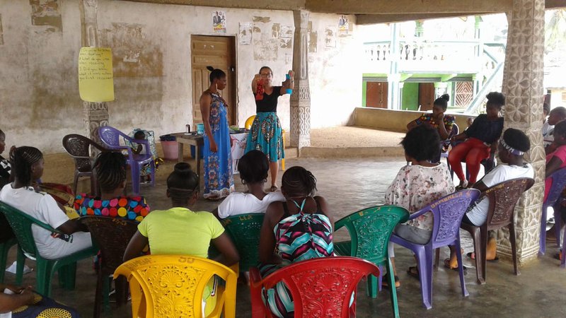 Peace Corps Volunteer Claire Hard teaches to a class of girls and women.
