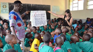 DCM & PC Staff reads out a big book for pupils.JPG
