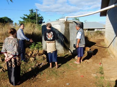 Rotary Club representative inspects tank with PCV couple and their principal
