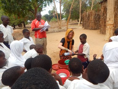 Emily's 6-year-old neighbor helping her demonstrate handwashing for the Mazingira Mazuri crowd after making a handwashing station.