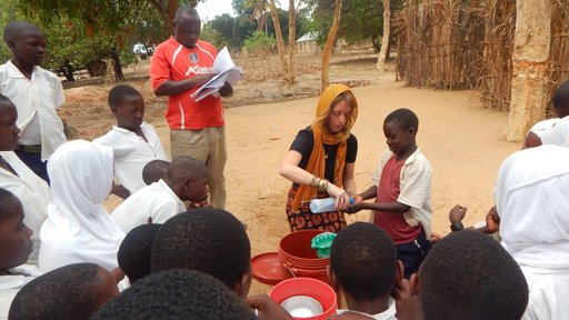 Emily's 6-year-old neighbor helping her demonstrate handwashing for the Mazingira Mazuri crowd after making a handwashing station.