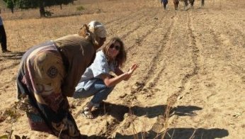 Peace Corps Volunteer Chelsea Rinnig works with a community member to make lines with a “ripper,” a tool that assists in the strip plowing process.