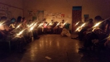 A group of Malawian girls participate in a candle lighting ceremony.