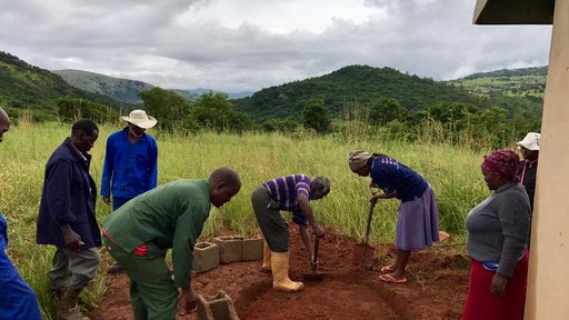 Community members preparing area water tank will be built on.